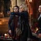 Clarke, a blond woman in a leather jacket, points a gun at someone off screen. Behind her three other women look on in shock and horror.